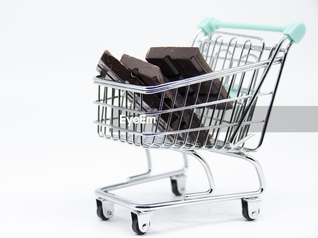 Close-up of chocolates in shopping cart on white background