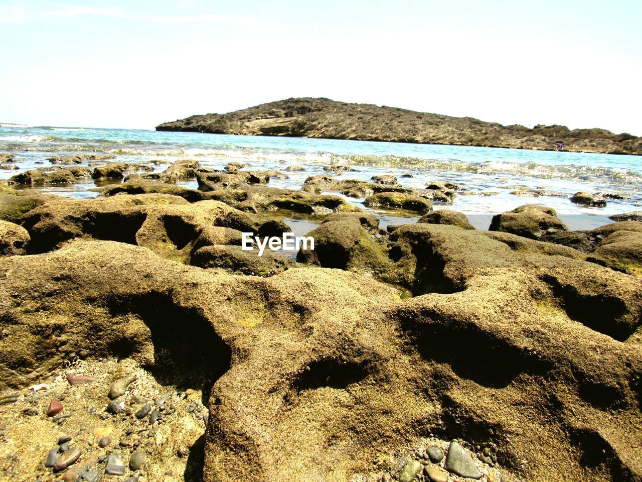 CLOSE-UP OF ROCKS IN SEA AGAINST SKY