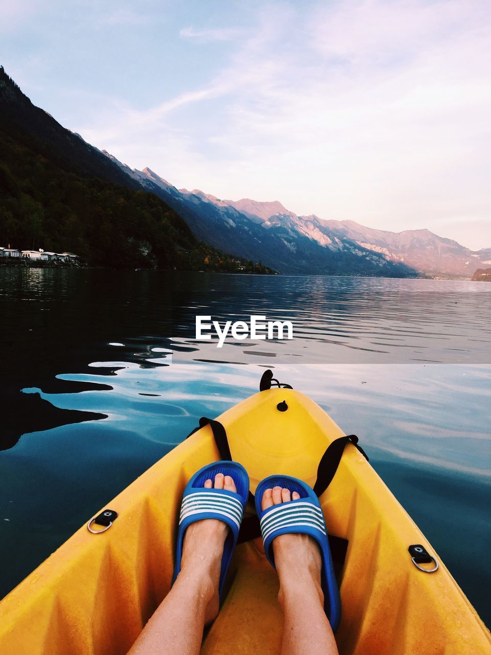 Low section of person on kayak in sea against sky