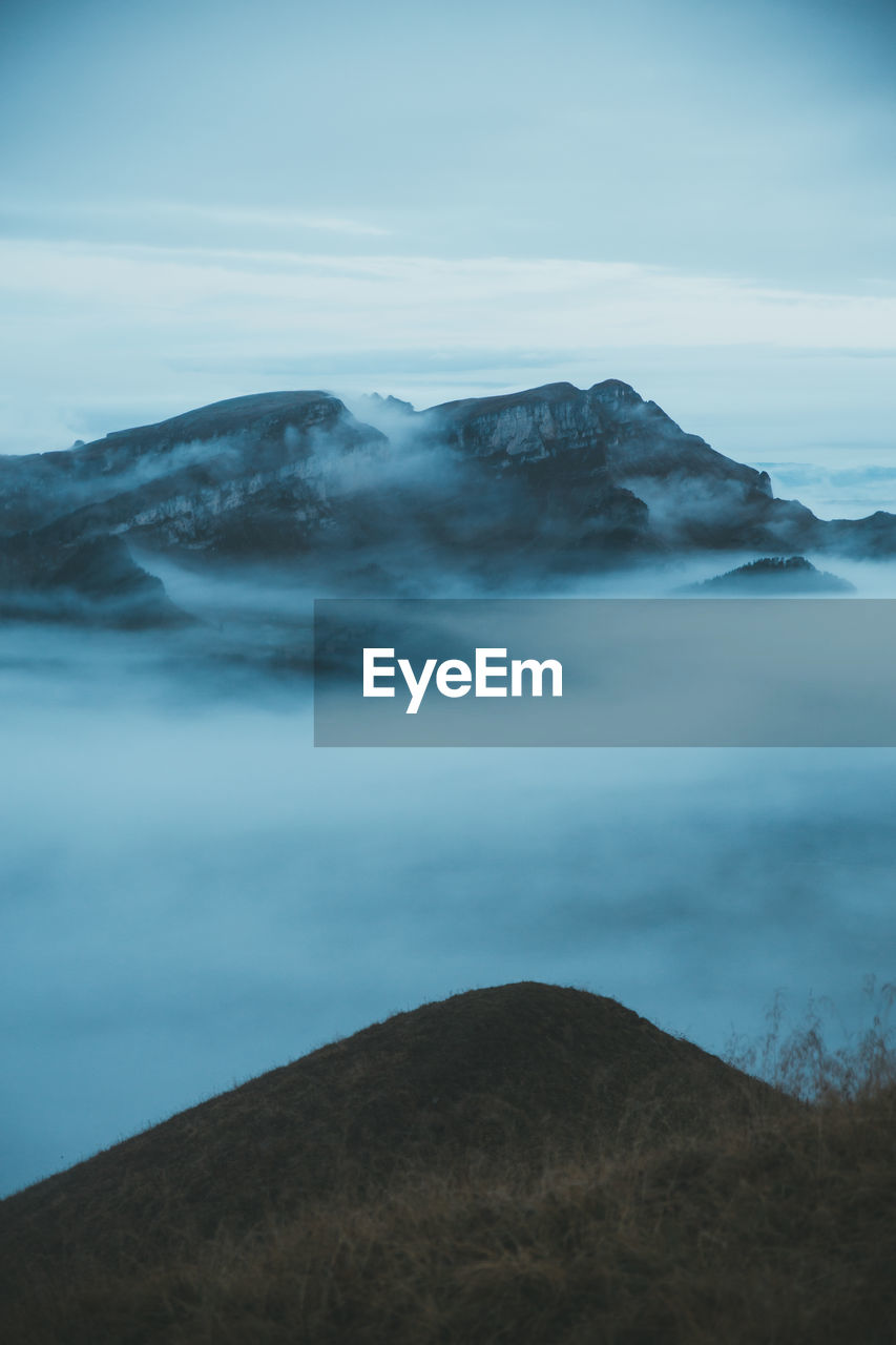 Scenic view of sea and mountains against sky