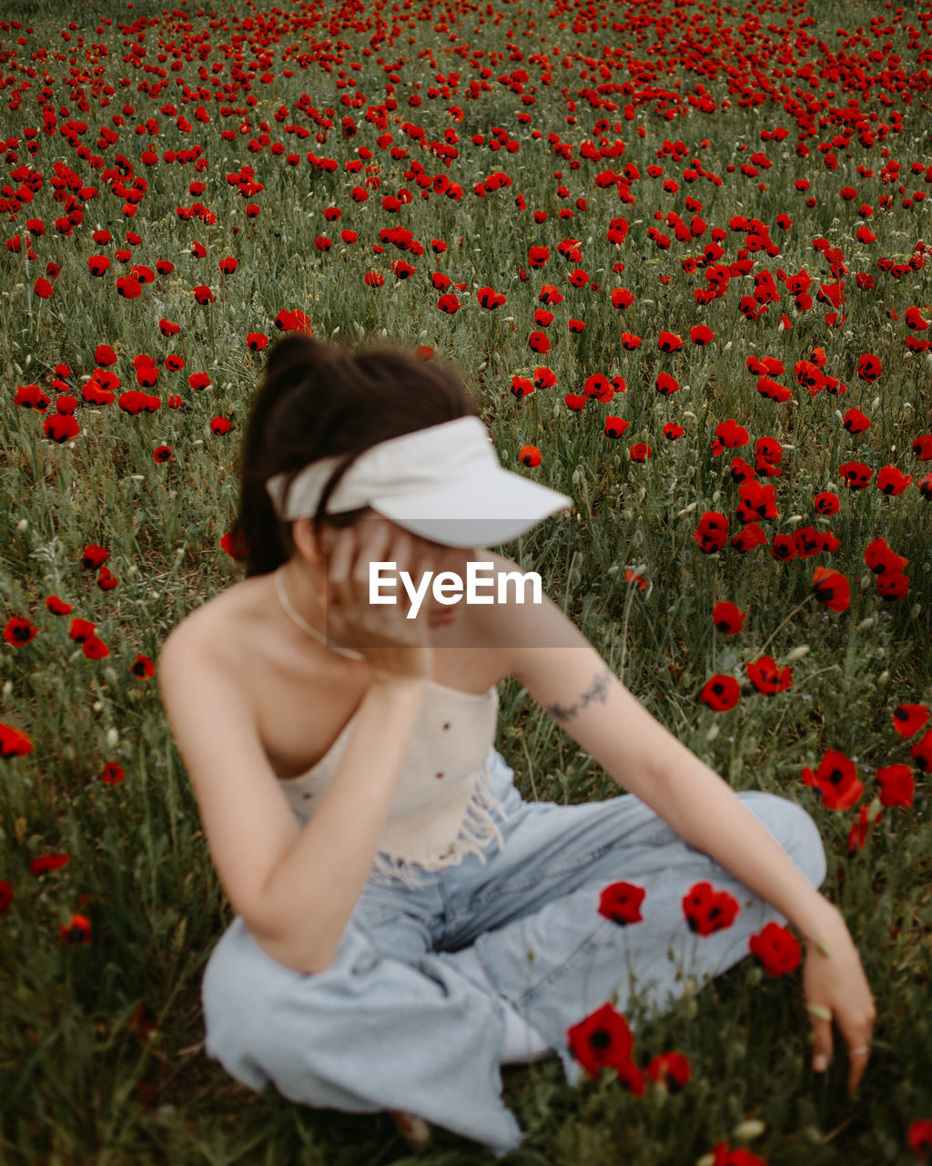 Woman sitting cross-legged in flower field