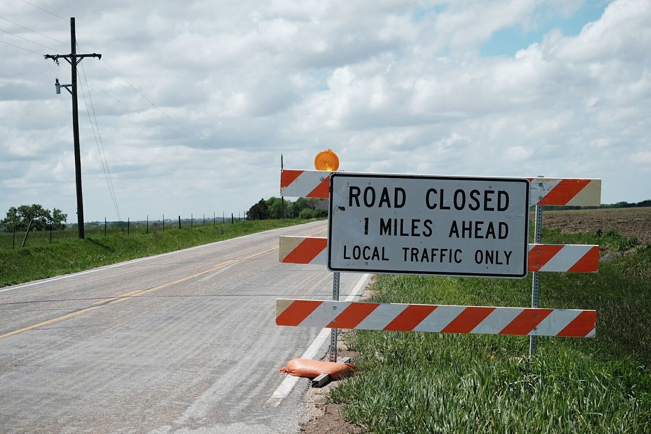 Close-up of road sign by countryside street