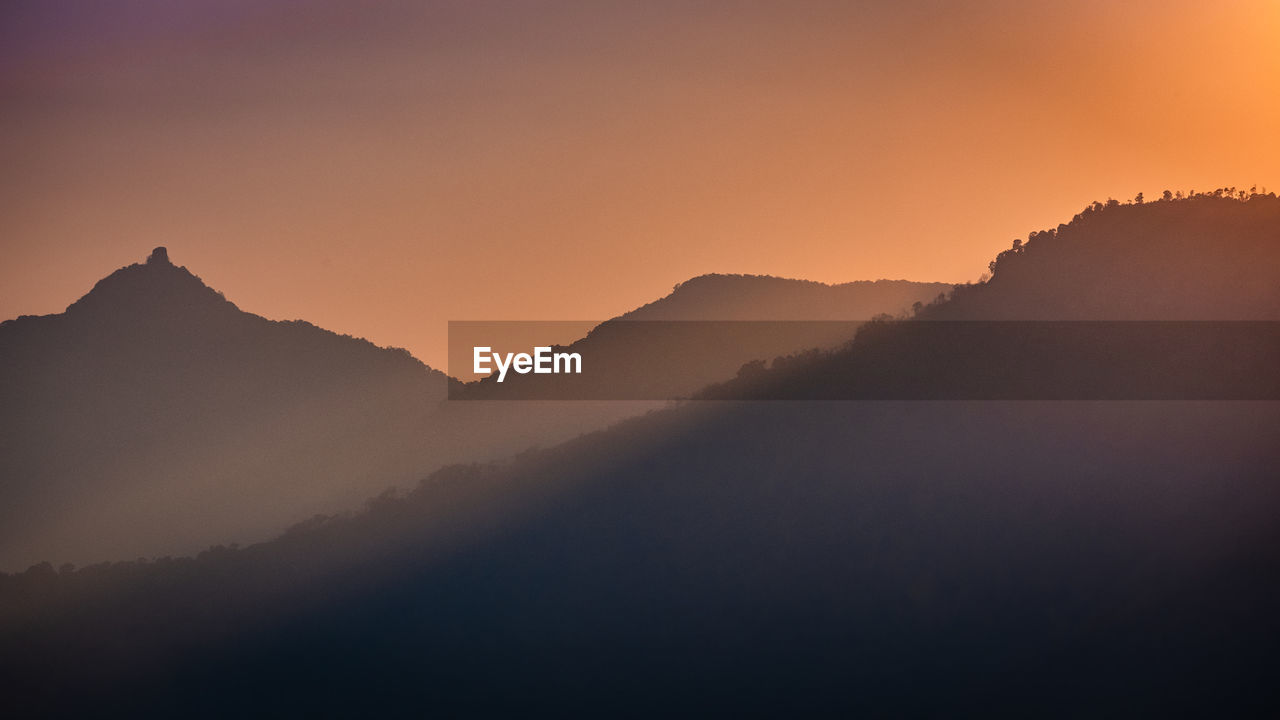 Scenic view of silhouette mountains against sky during sunset