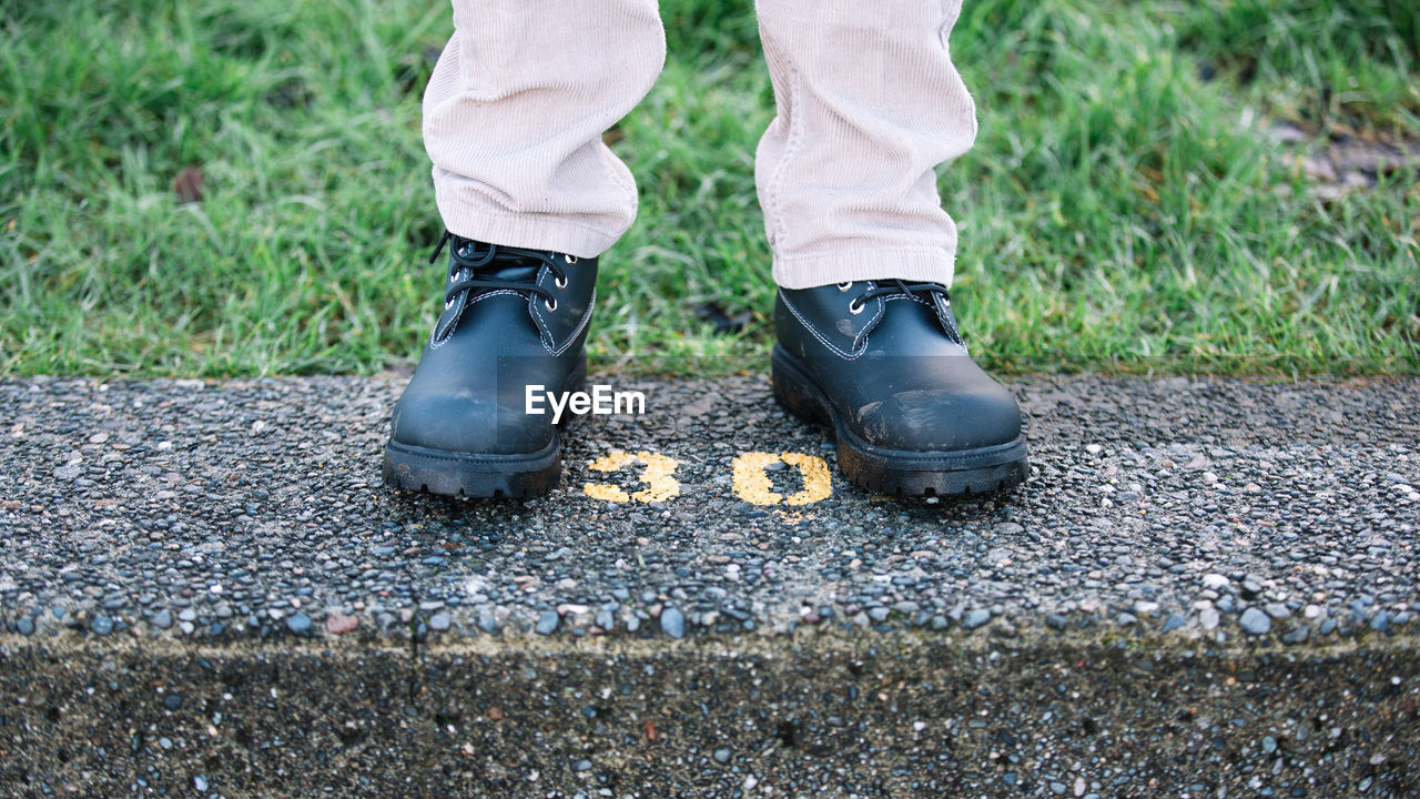 Low section of person standing on stone railing