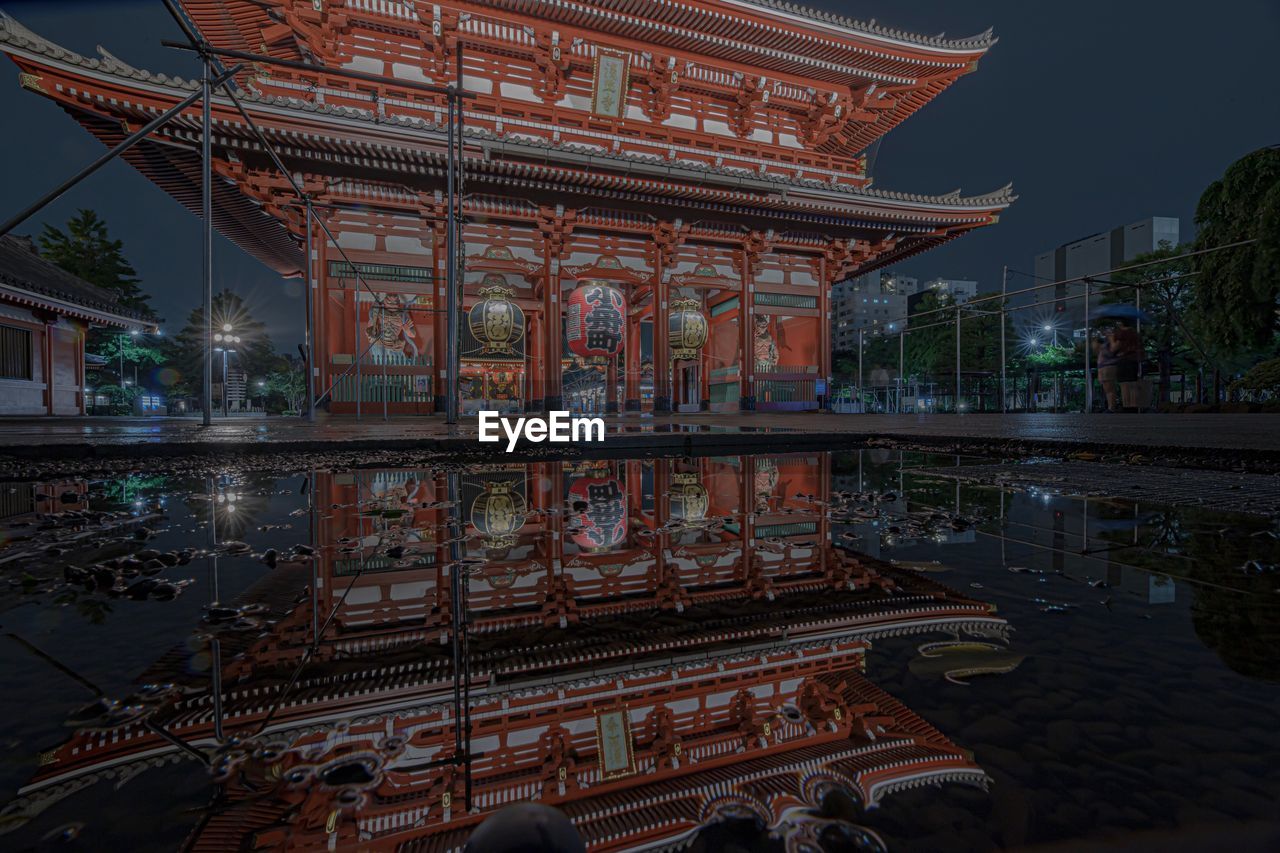 REFLECTION OF BUILDING IN WATER AT NIGHT