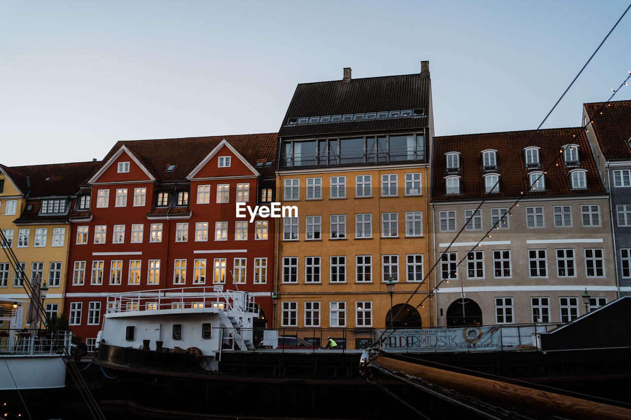 architecture, building exterior, built structure, waterway, building, cityscape, city, transportation, urban area, sky, mode of transportation, nature, evening, water, nautical vessel, window, clear sky, canal, residential district, travel destinations, no people, boat, vehicle, downtown, travel, house, town, outdoors, day, row house, tourism, city life, ship, watercraft