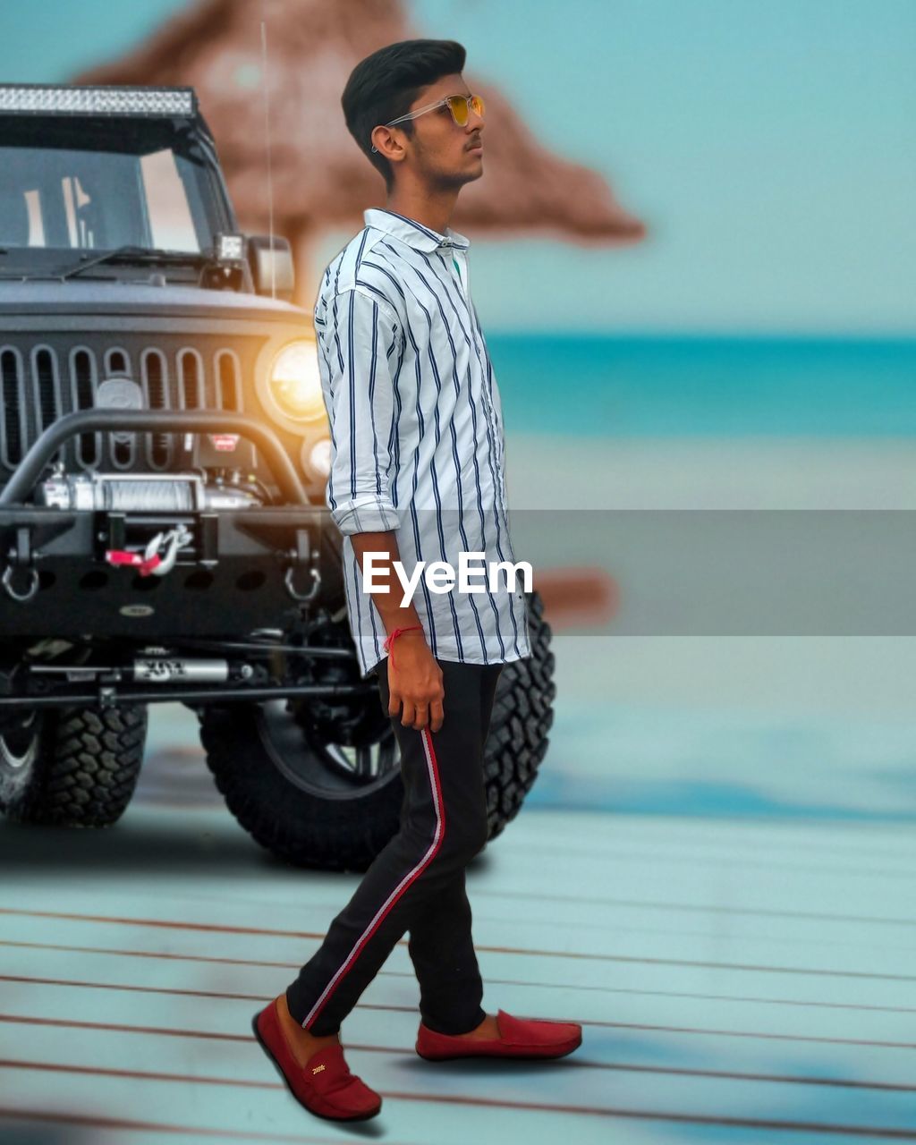 YOUNG MAN STANDING ON CAR