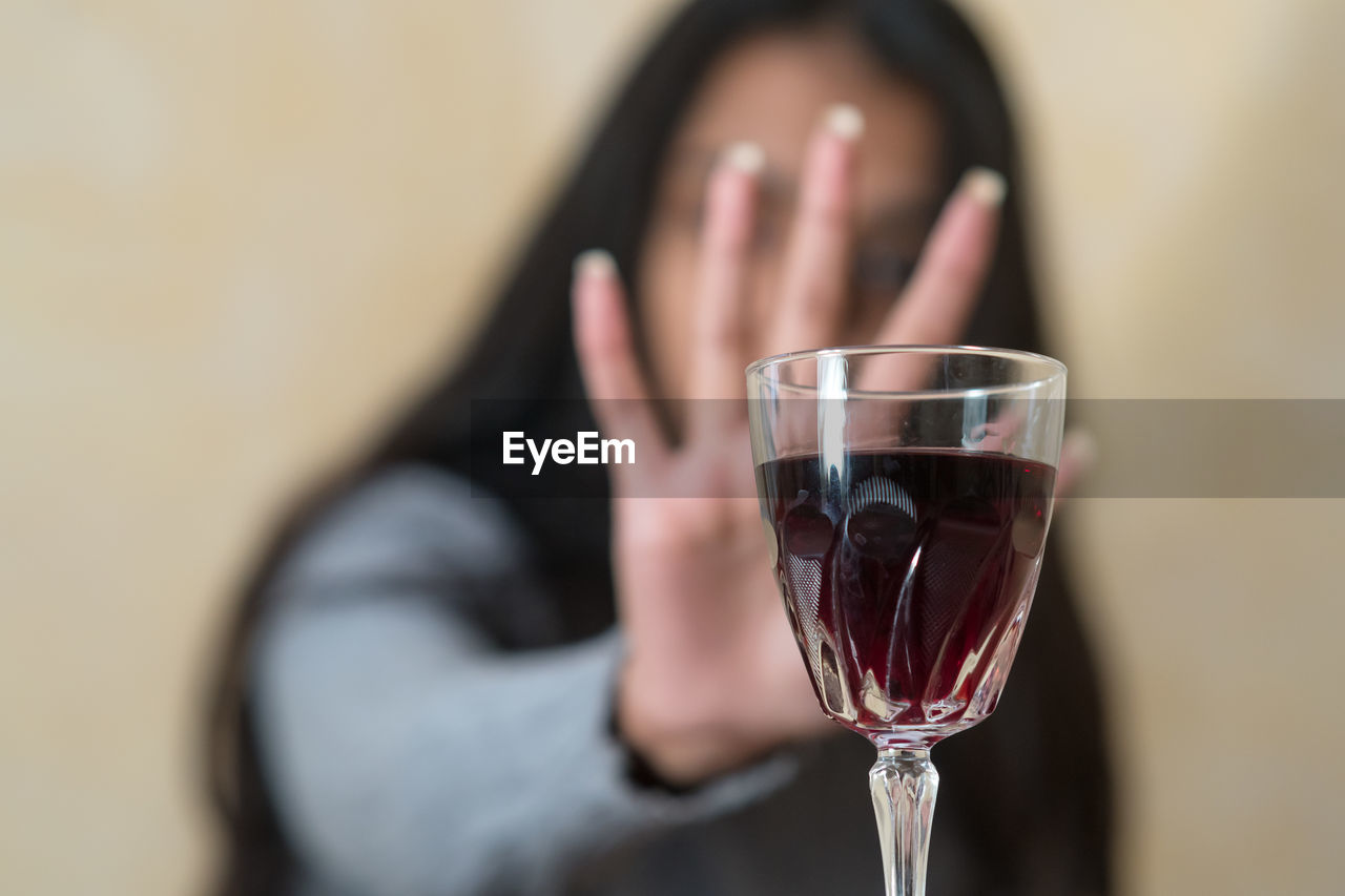 CLOSE-UP OF WOMAN HOLDING GLASS OF WINE