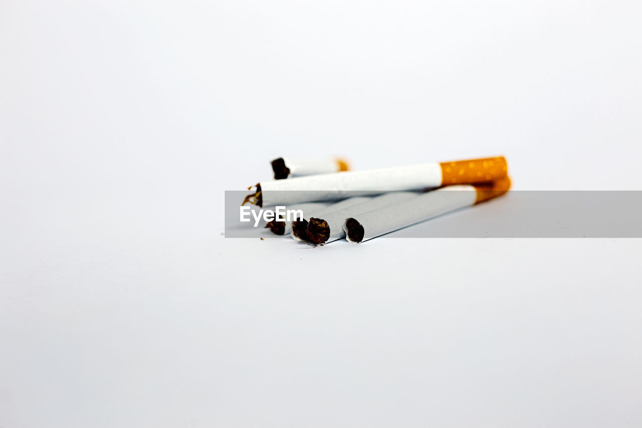 Close-up of cigarette smoking against white background