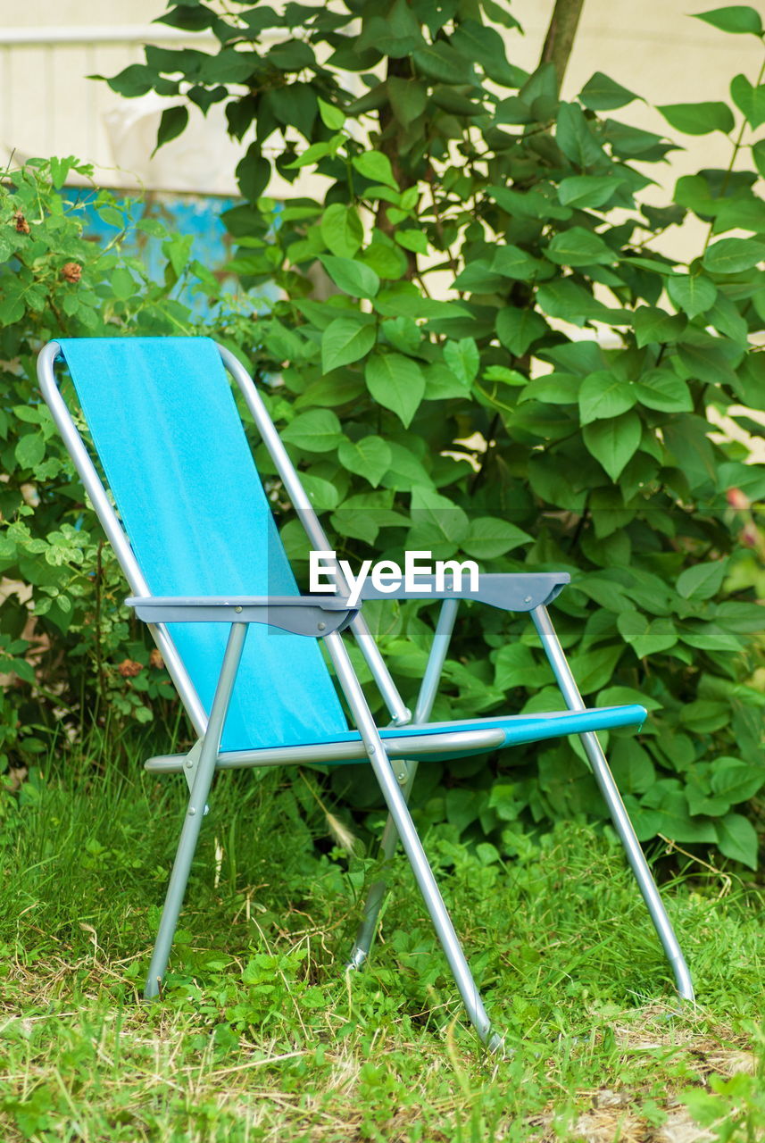 Empty chair on field at backyard