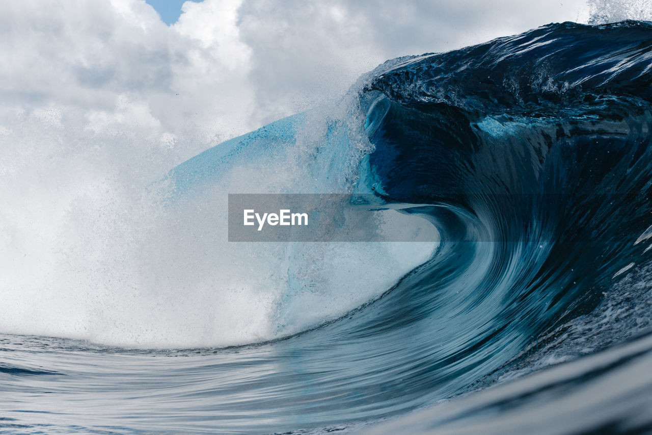 Close-up of wave splashing on shore against sky