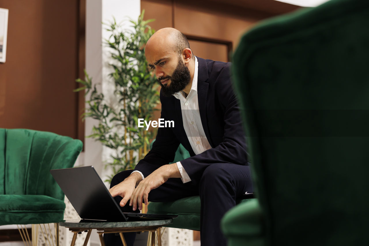 side view of man using laptop at office