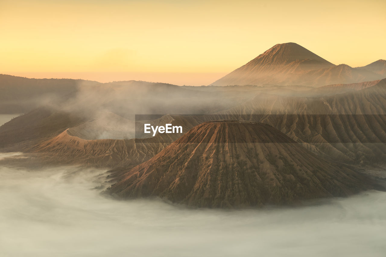 Scenic view of volcanic landscape against sky during sunset