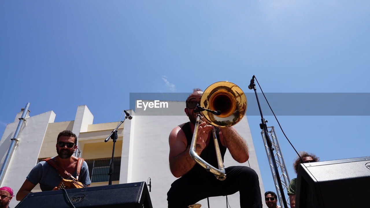 LOW ANGLE VIEW OF MAN SITTING ON STAGE