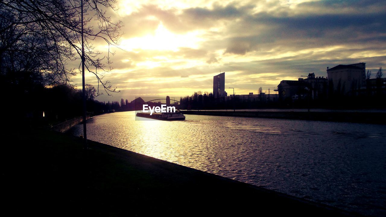 VIEW OF RIVER AGAINST CLOUDY SKY AT SUNSET