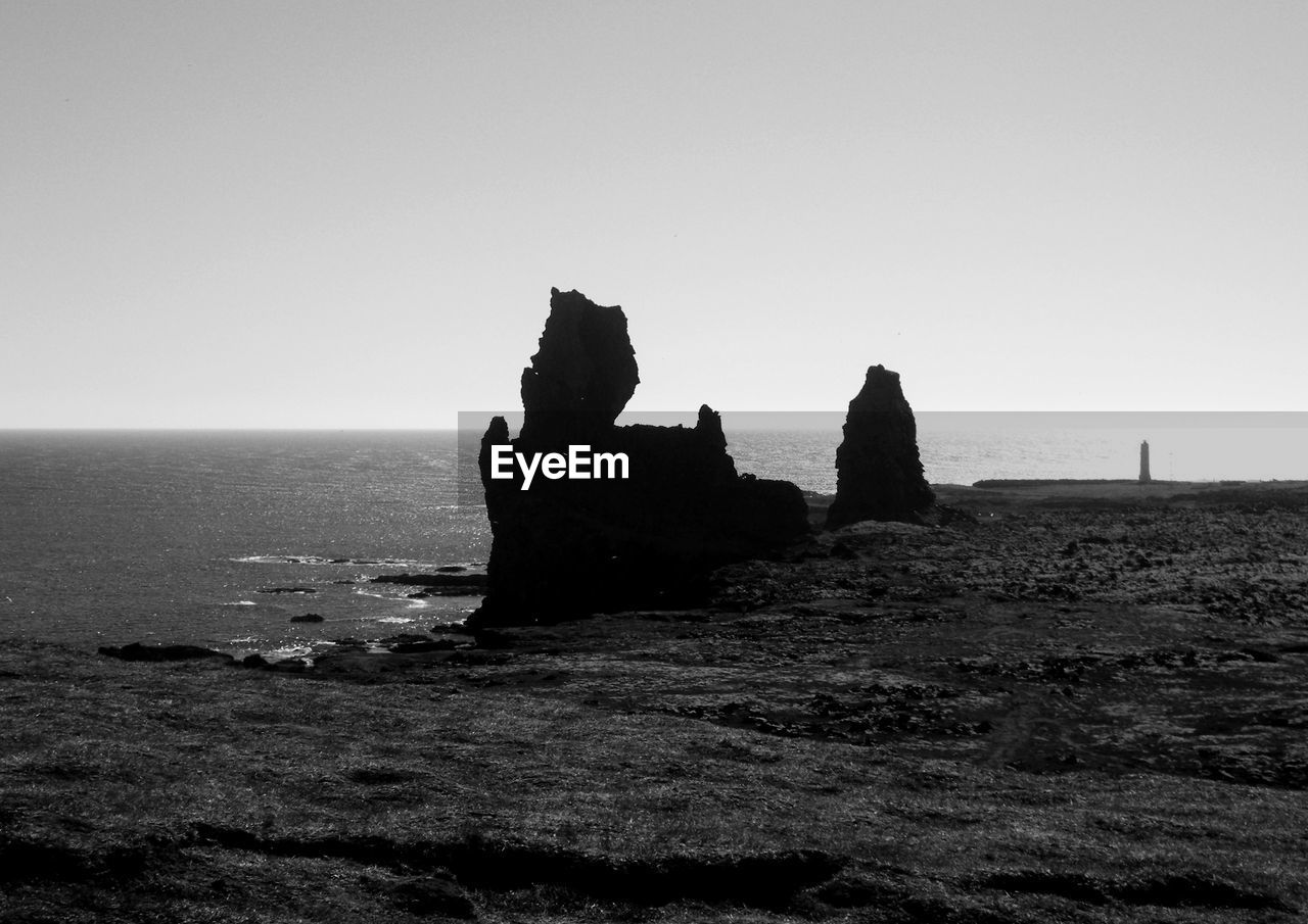 Scenic view of rock formation in sea against clear sky