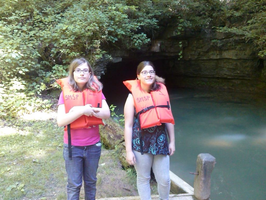 Portrait of teenage girls wearing life jackets at lakeside