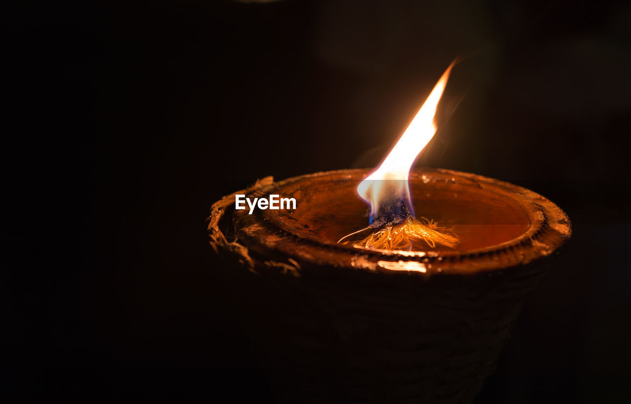 Close-up of lit lantern against black background