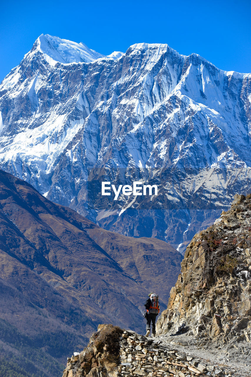Woman climbing on mountains against sky