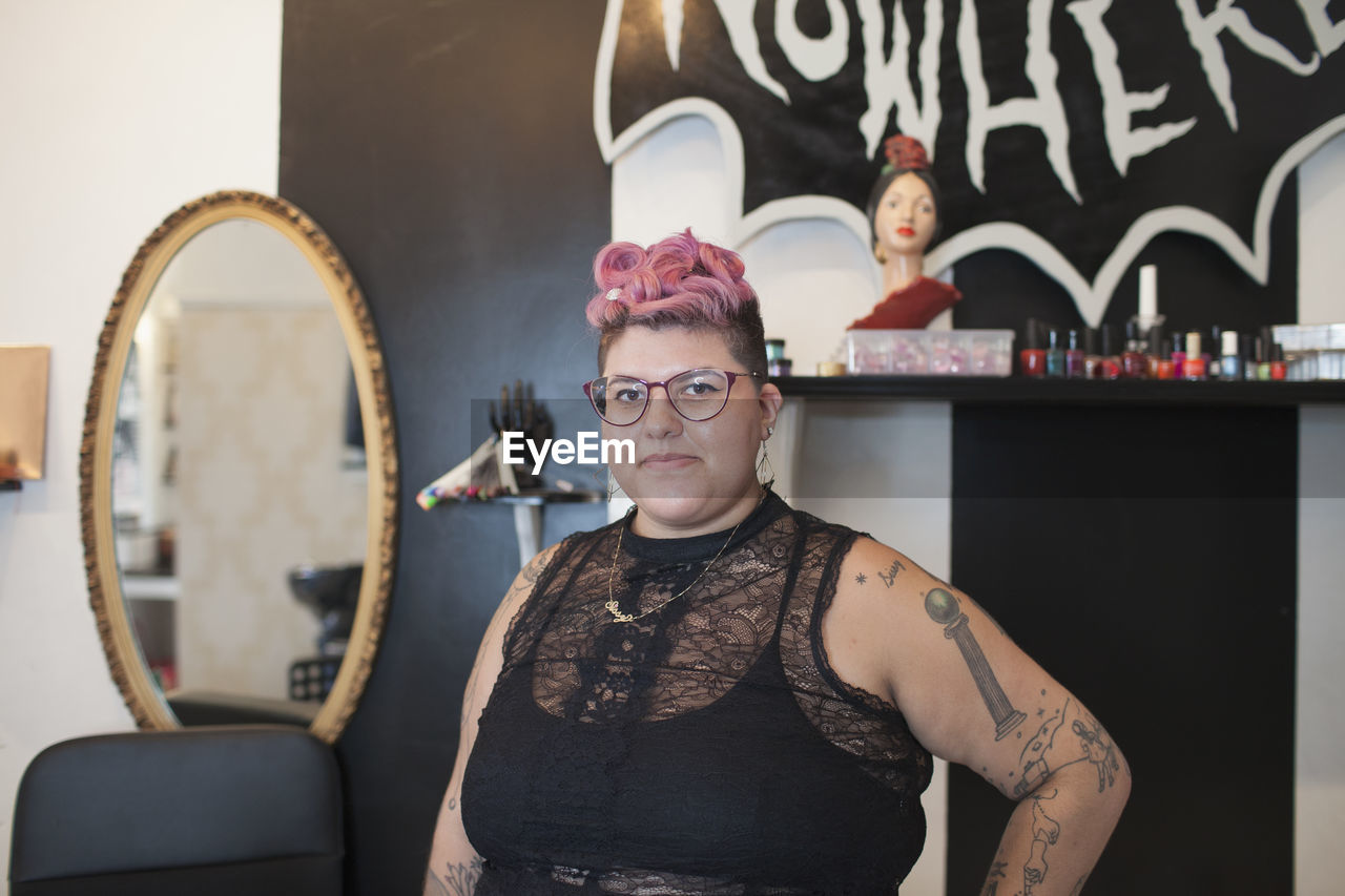 A portrait of a young woman with pink hair.