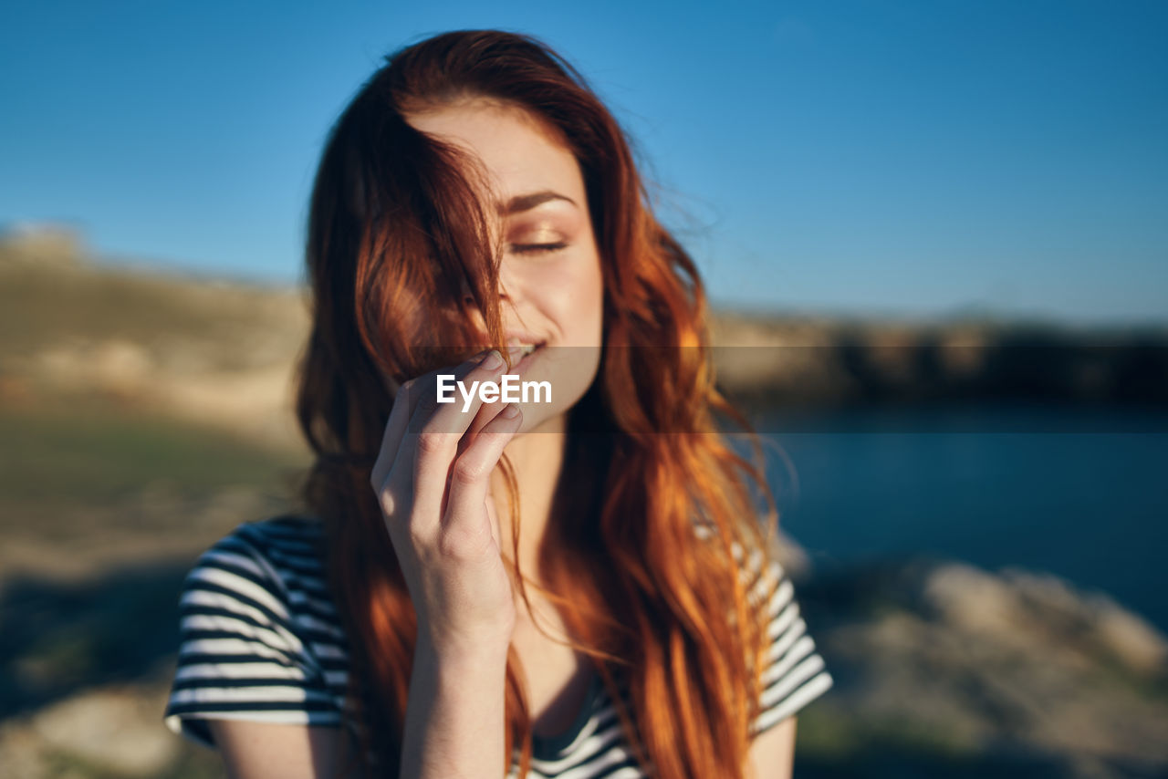 Close-up of beautiful woman against sky