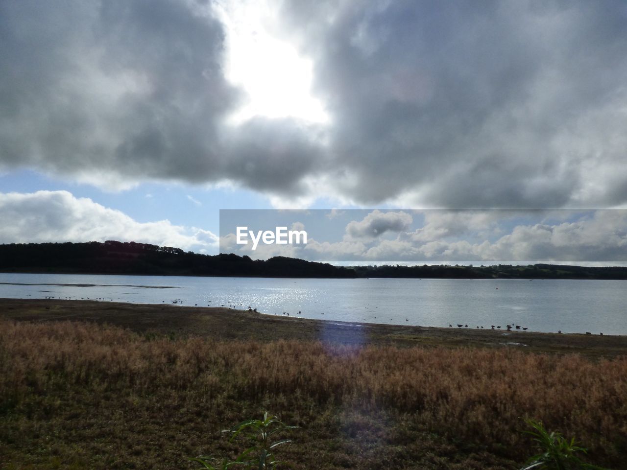 VIEW OF LAKE AGAINST CLOUDY SKY