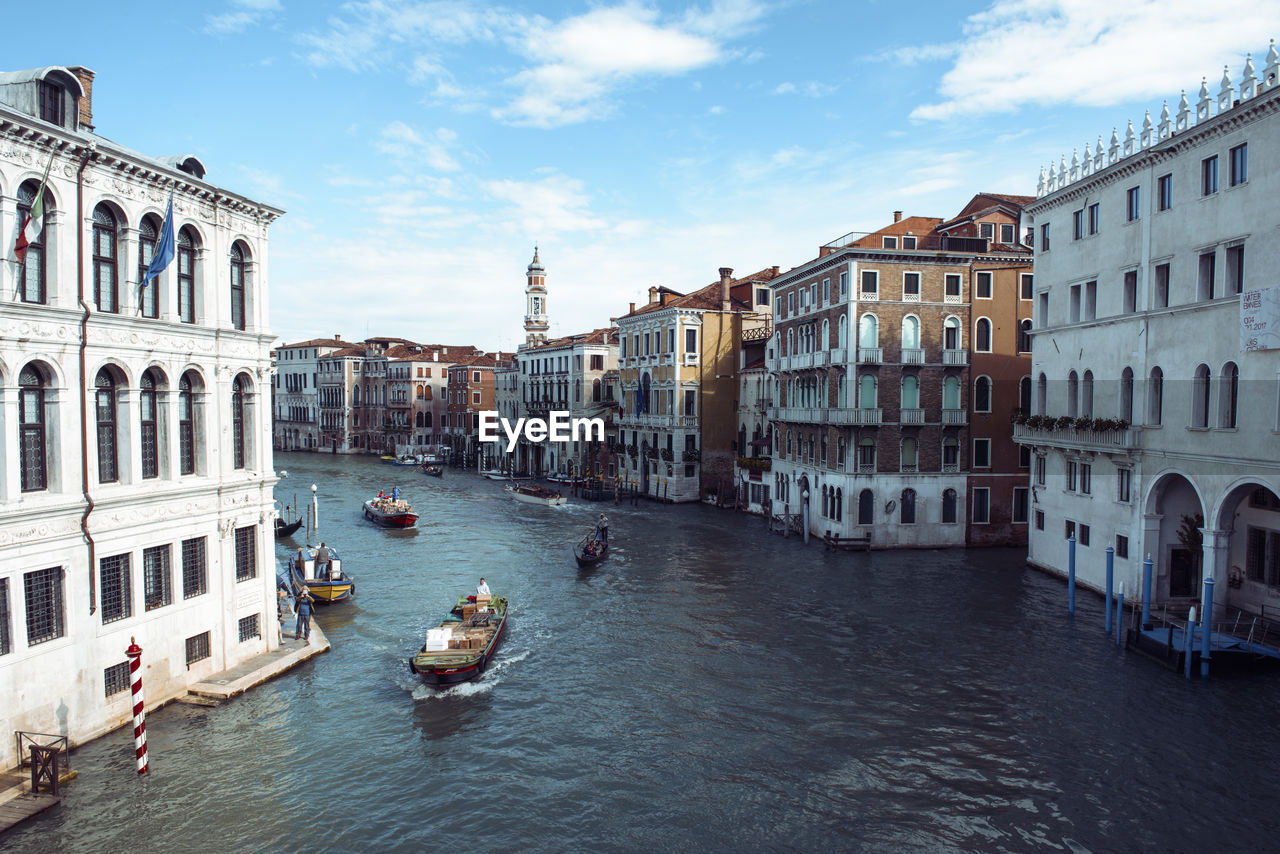 BOATS IN CANAL AMIDST BUILDINGS