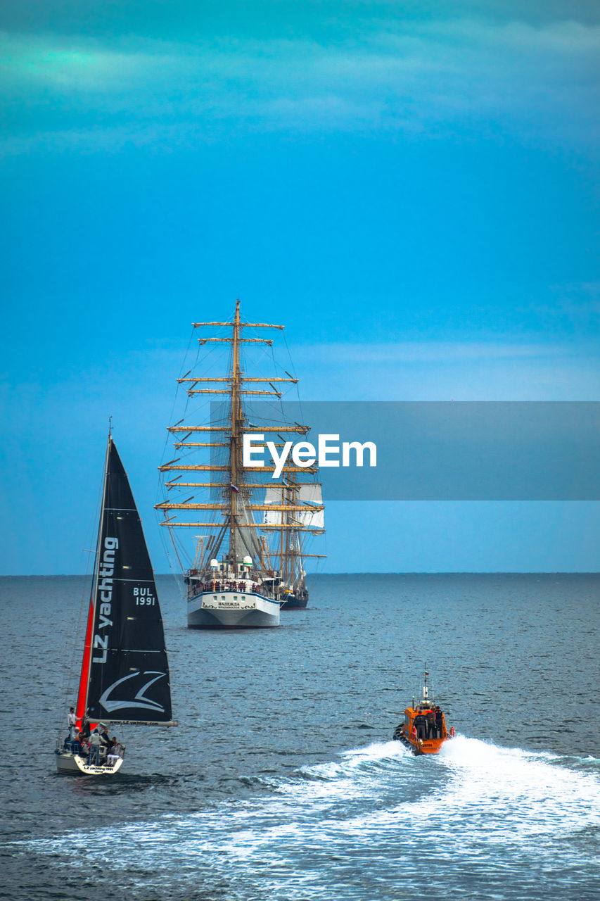 Boat sailing in sea against blue sky