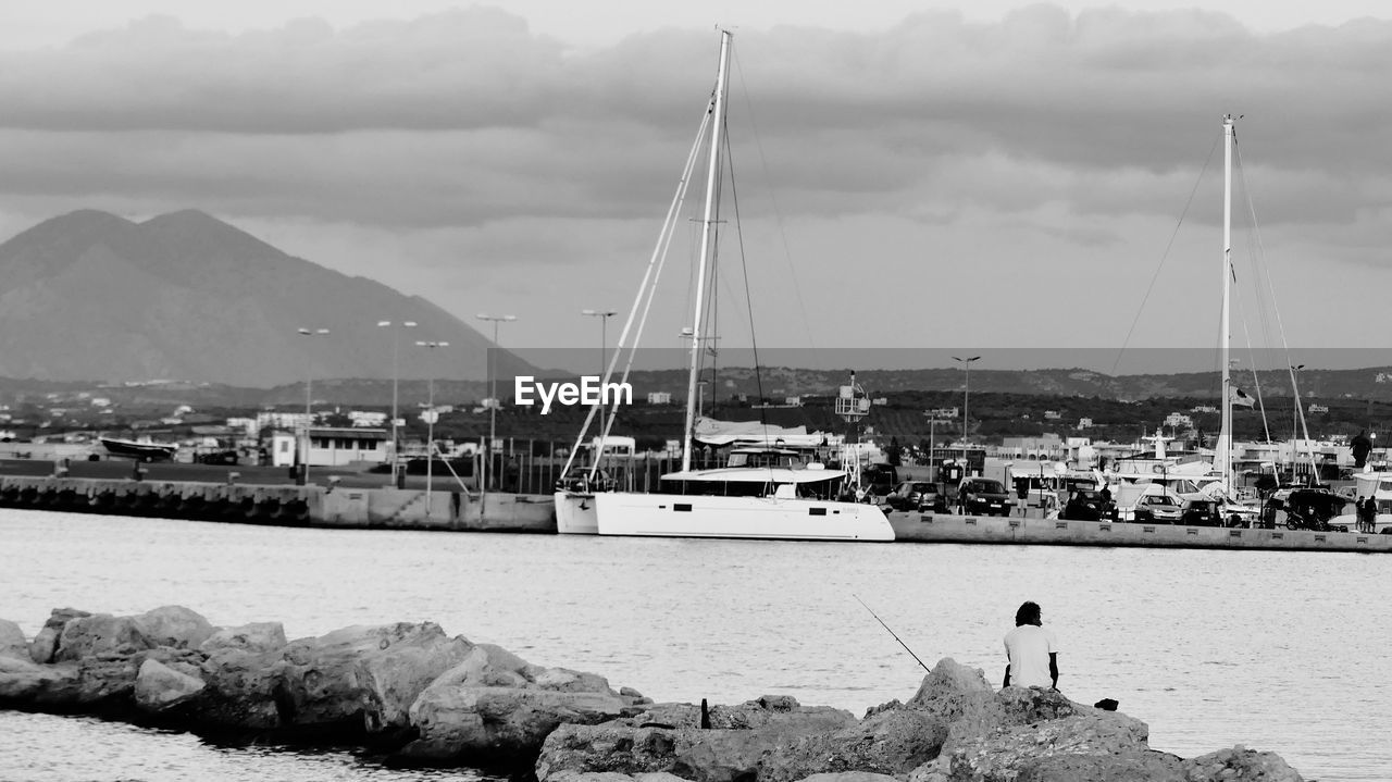 SAILBOATS MOORED ON SEA AGAINST SKY