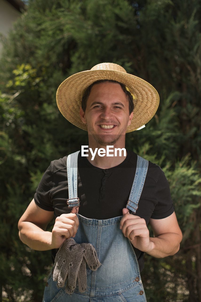 Portrait of smiling man standing against trees