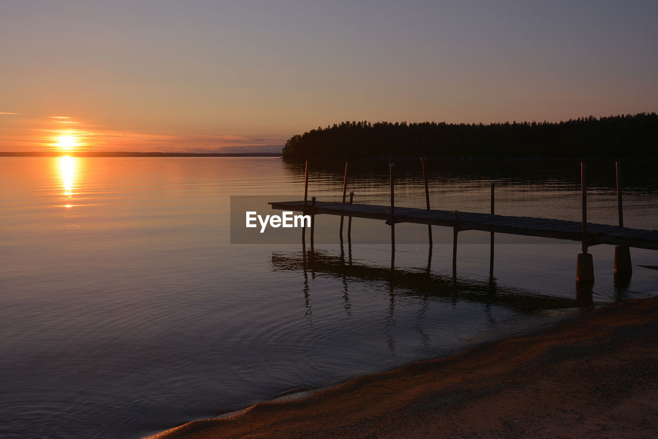 Scenic view of lake against sky at sunset