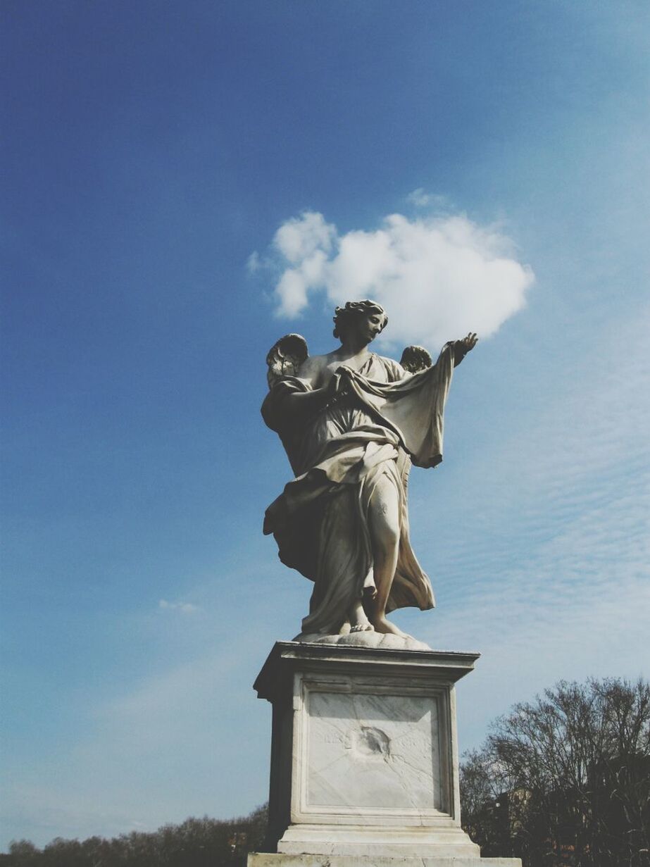Low angle view of a statue against blue sky