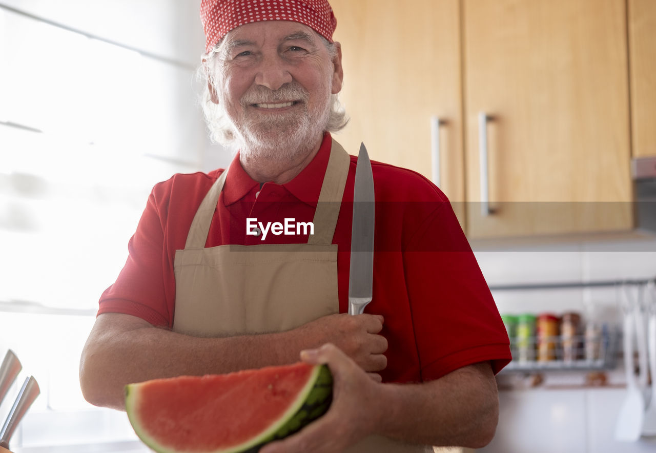 Portrait of smiling man holding watermelon