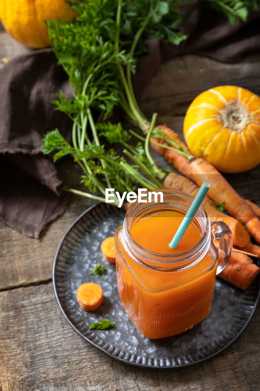 Fresh natural mixed juice, healthy food concept. glass jar of fresh carrot juice with fresh carrots