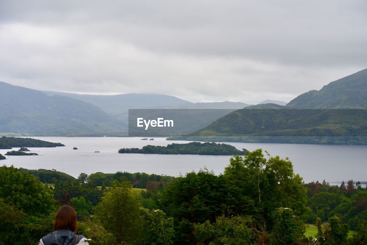 Rear view of woman looking at lake and mountains