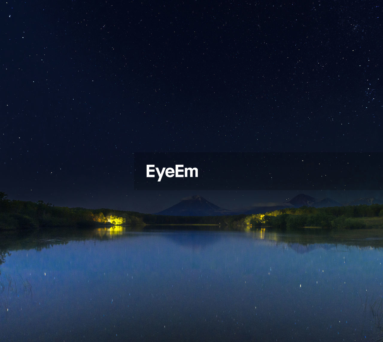 Scenic view of lake against sky at night