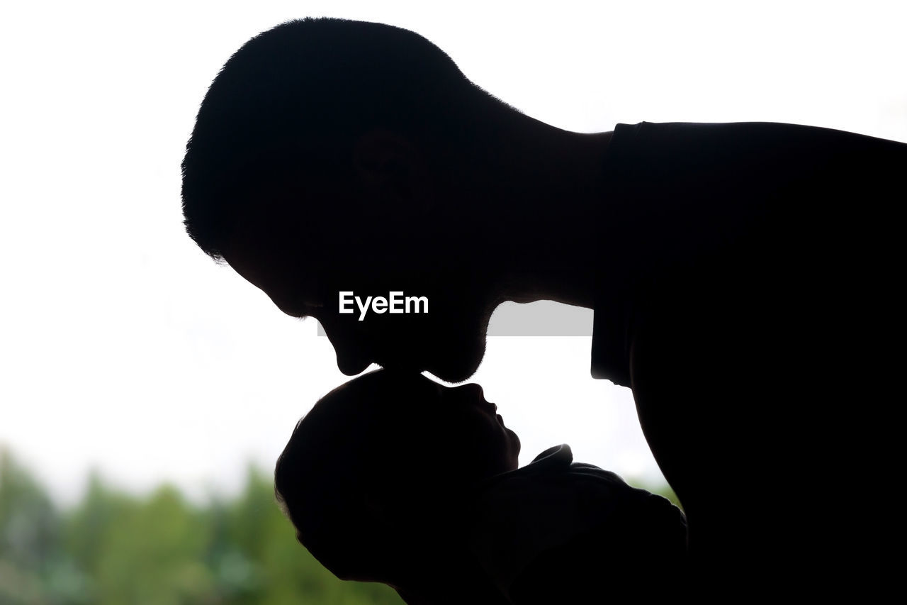 Close-up portrait of silhouette man statue against sky