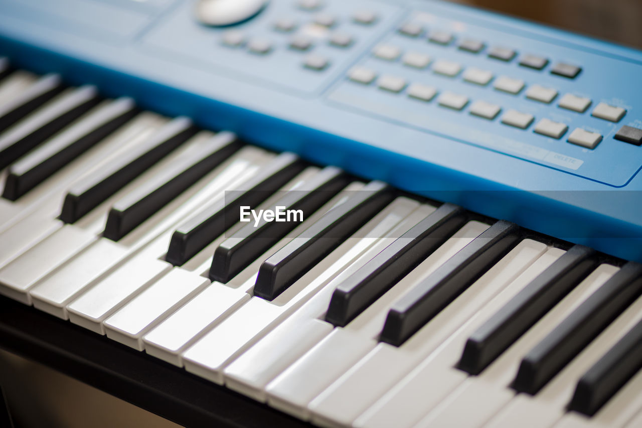 Black and white keyboard keys on a modern blue synthesizer.