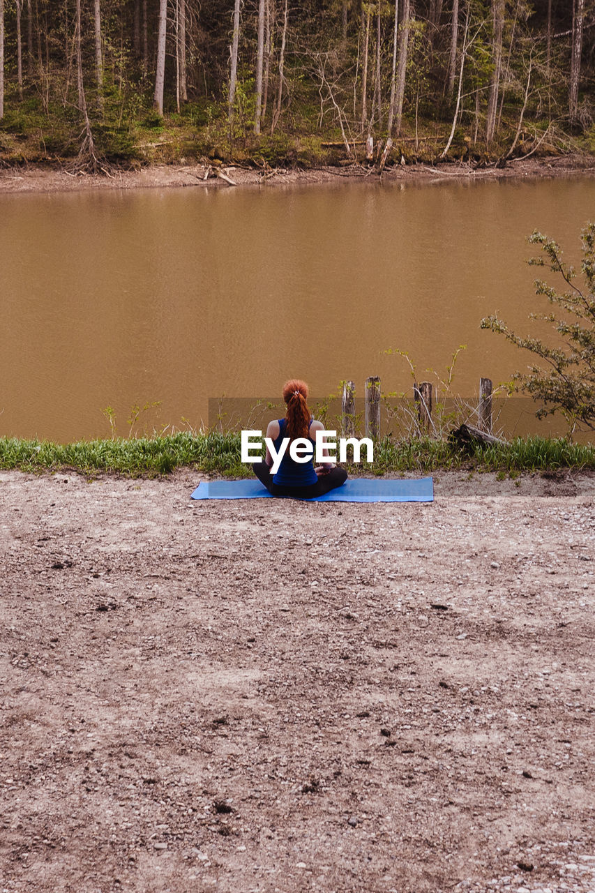 WOMAN SITTING ON SHORE