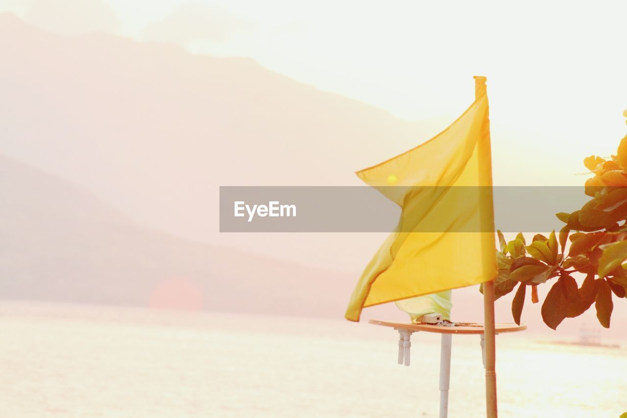 Scenic view of yellow flag against mountains