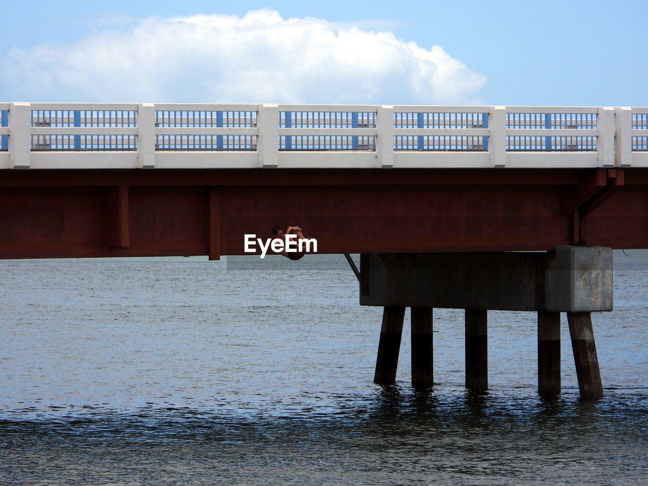 MAN ON PIER AMIDST SEA AGAINST SKY