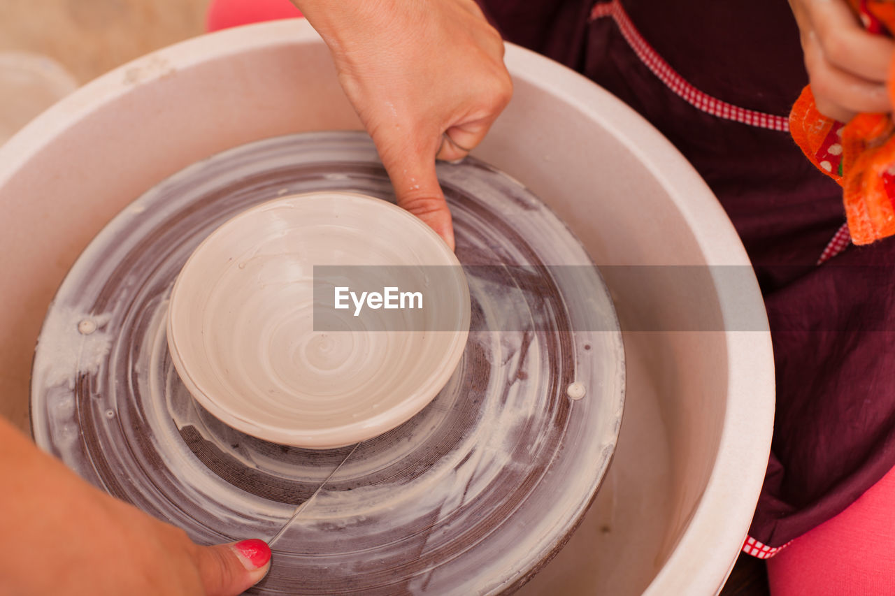 Midsection of girl using pottery wheel