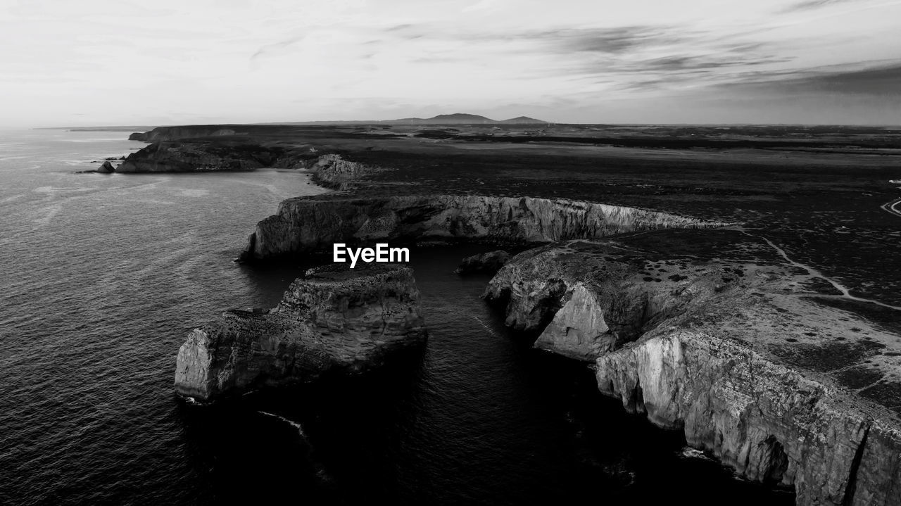 High angle view of rocks by sea against sky