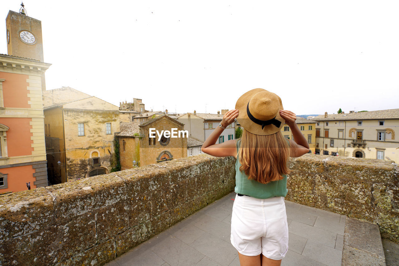 Traveler girl enjoying townscape of orvieto from a terrace of historic palace, orvieto, umbria,italy