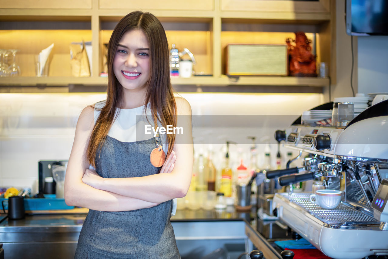 Portrait of smiling woman standing in kitchen