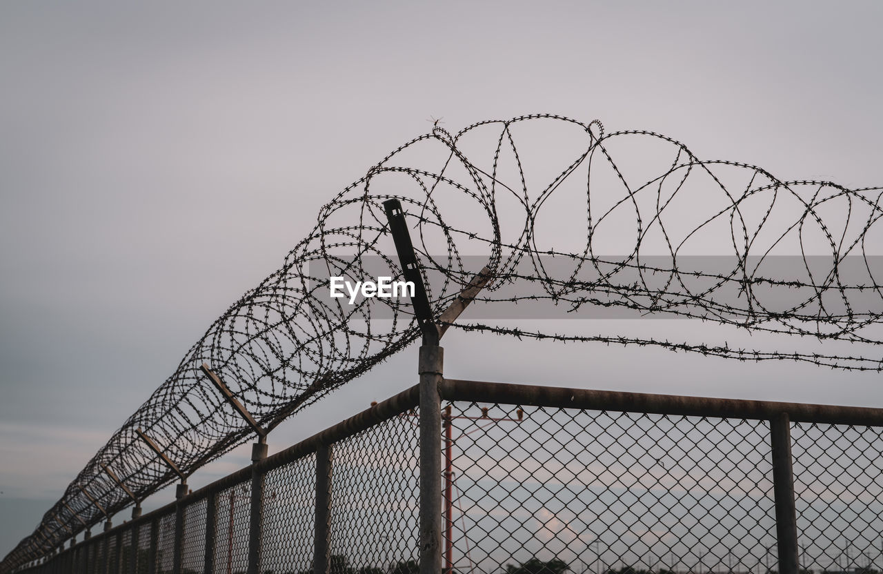 Prison security fence. barbed wire security fence. razor wire jail fence. barrier border. boundary.