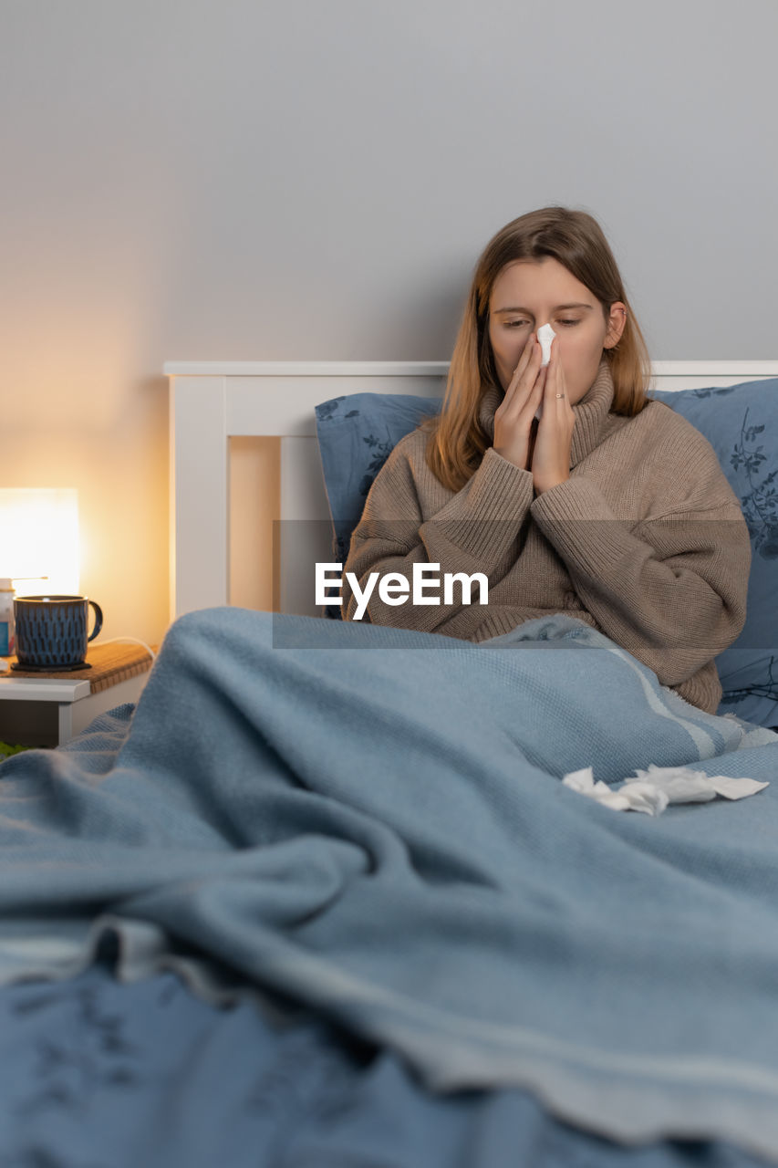 Sick woman resting on bed