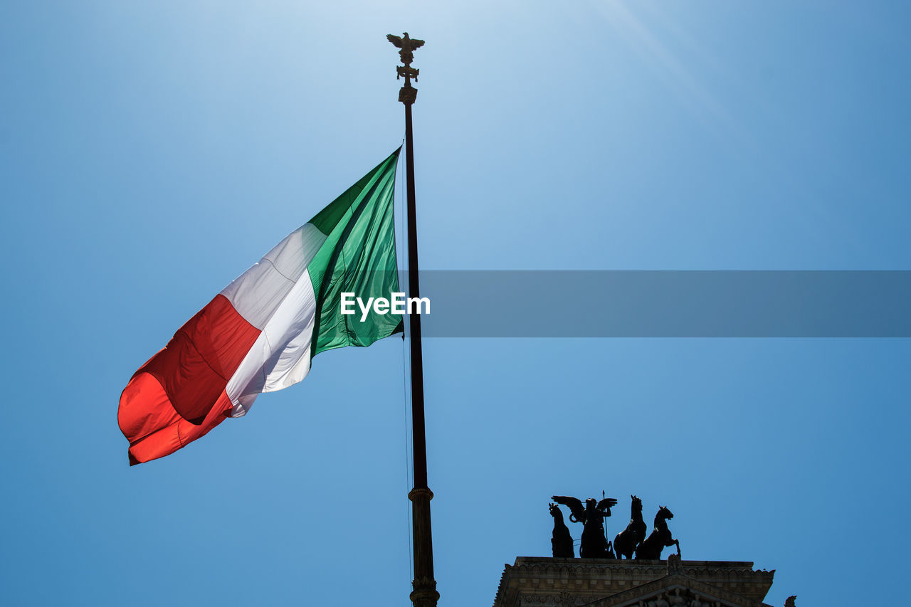 Low angle view of italian flag against clear blue sky