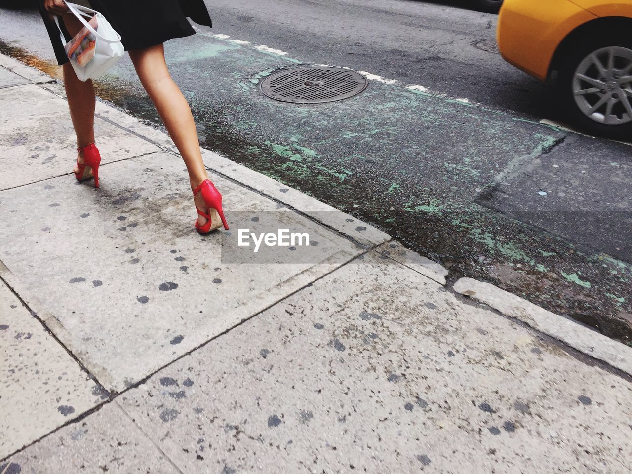 Low section of woman walking on street