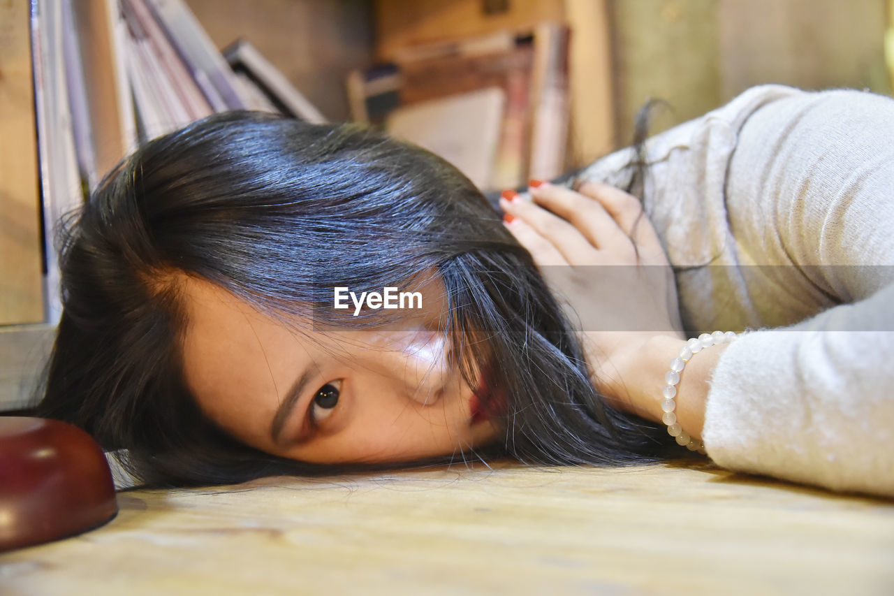 Portrait of woman lying on table